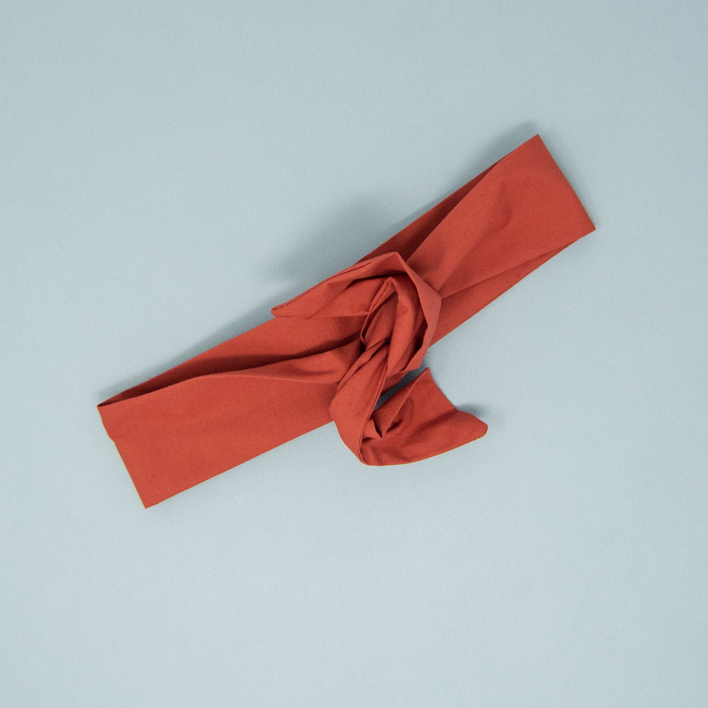 Bandeau à torsader couleur rouille, posé à plat