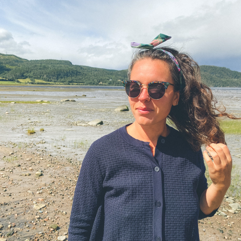 Marie-Andrée est devant le fjord, se joue dans les cheveux et porte un bandeau