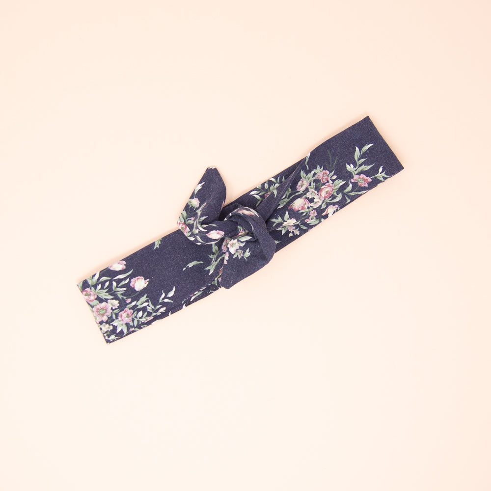 Bandeau à torsadé aux motifs de petites fleurs roses sur fond marine